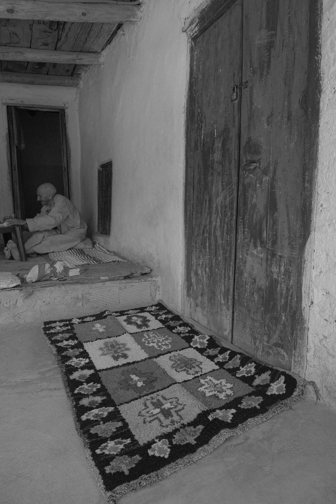 Une pièce aux murs blanchis, un tapis posé au sol